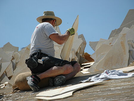 Handwerker beim Decken eines Legschieferdachs