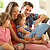 Parents Sitting With Children Reading Story Indoors