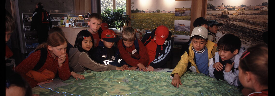 Kinder lassen sich an einem Modell des Fränkischen Seenland den Lebensraum Altmühlsee erklären