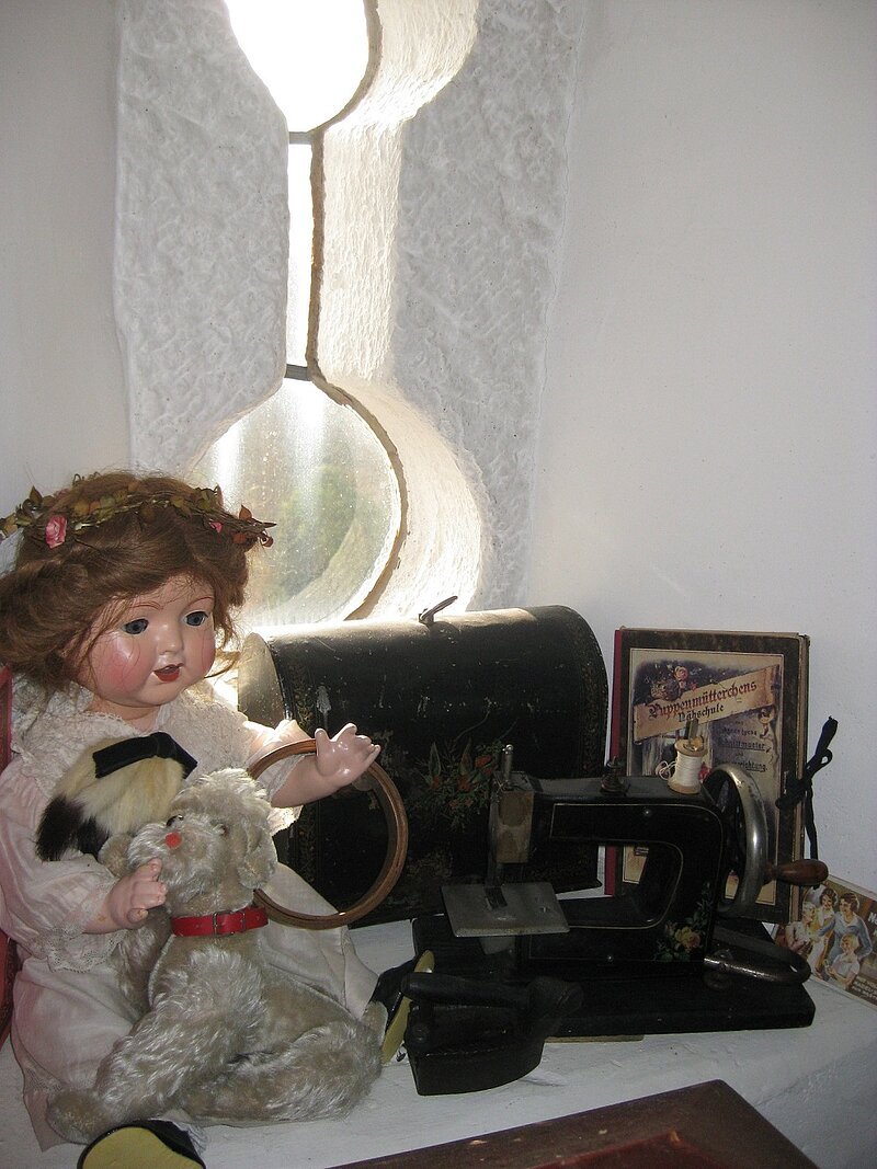 Eine alte Puppe als Ausstellungsstück im Museum.