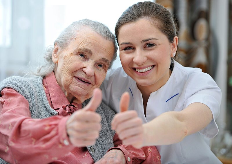 Seniorin mit Pflegerin Senior woman and female nurse are showing thumbs up. Eine ältere Frau mit ihrer Pflegerin