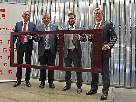 Landrat Gerhard Wägemann mit den Vertretern der Gutmann AG während der Betriebsbesichtigung bei der Präsentation eines Rahmens