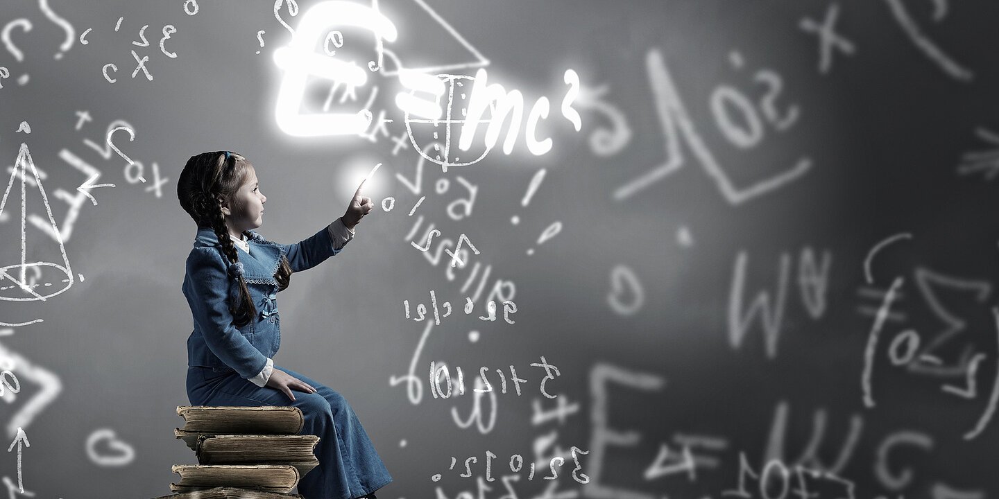 Little girl sitting on stack of books and touching science formula