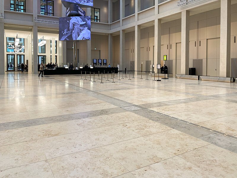 Es ist das Humboldt-Forum Berlin von innen zu sehen. Es ist zu sehen, dass das Gebäude mit Naturstein gebaut wurde.