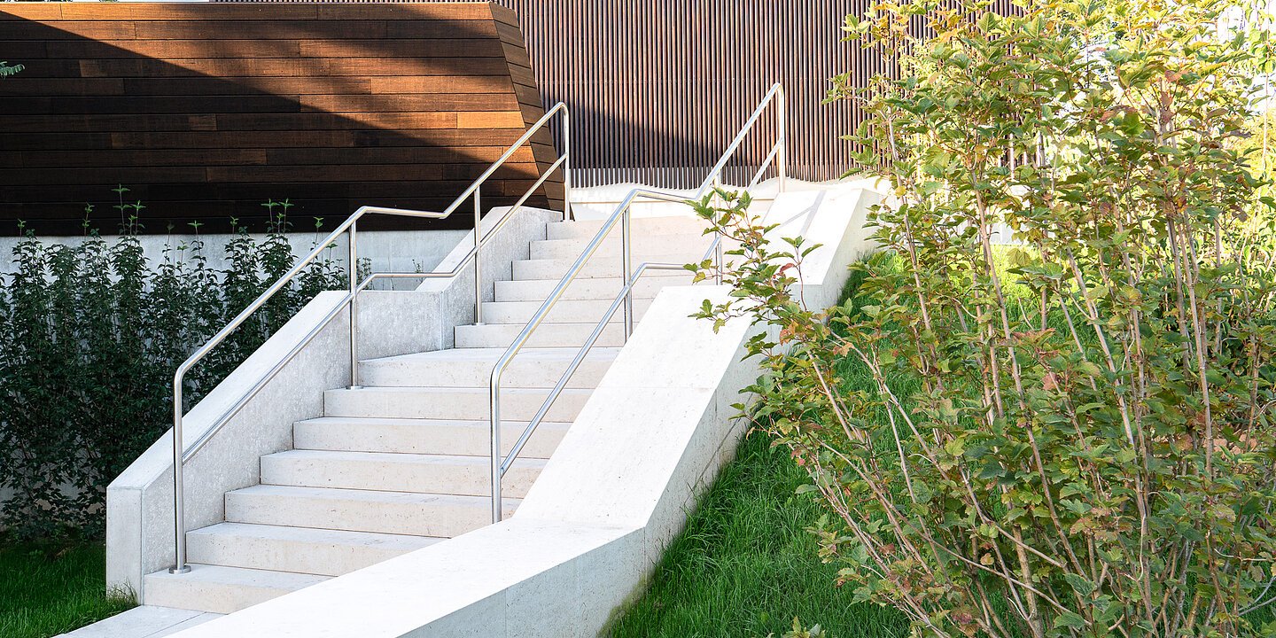 Es ist eine weiße Natursteintreppe im Außenbereich der Altmühltherme Treuchtlingen zu sehen.