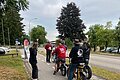 Einige Radler fahren auf dem Radweg und kommen am Pendlerfrühstück vorbei. Sie bekommen von Landrat Manuel Westphal eine Frühstückstüte.