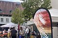 Der Infostand an der Sternfahrt mit einem weißen Pavillon, einer bunten Tischdecke und einem bunten Beachflag mit Altmühlfranken Aufschrift.
