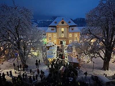 Blick auf den Weihnachtsmarkt in Ellingen mit Verkaufsständen und Schnee.
