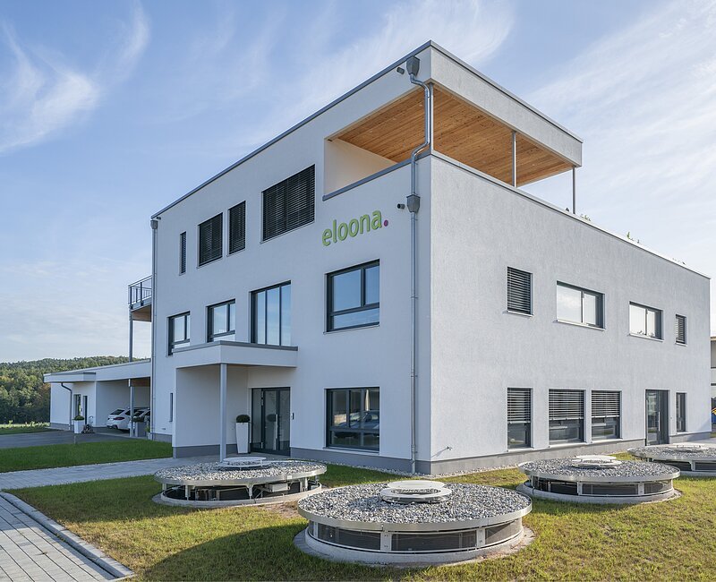Es ist das weiße Betriebsgebäude der Eloona GmbH aus Pleinfeld zu sehen.